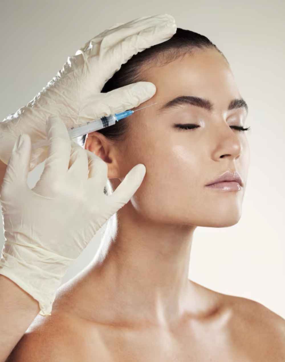 A practitioner in surgical gloves carrying out a facial treatment